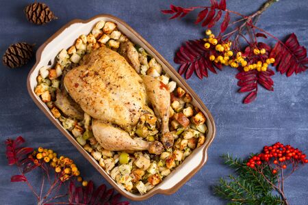 Roasted chicken with apple and bread stuffing in baking dish. View from above, topの写真素材