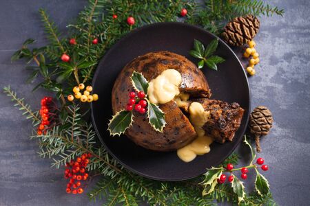 Christmas pudding decorated with sprig of holly. Cristmas decorations. View from above, topの写真素材