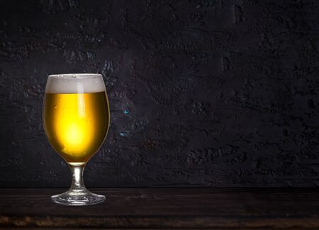 Glass of beer on wood dark background with copyspace for text