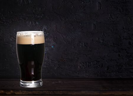 Glass of beer on wood dark background with copyspace for textの写真素材