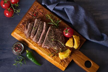 Grilled fillet beef steak with potatoes on serving board. View from above, top viewの写真素材