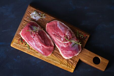 Raw fresh meat, duck breast fillet on wood chopping board. View from above, top viewの写真素材