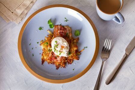 Potato cakes with topping: bacon and poached egg. Vegetable fritters, pancakes. View from above, top viewの写真素材