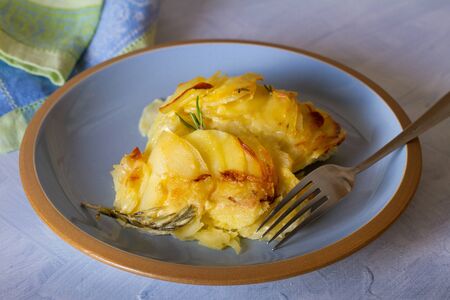 Potato gratin on blue plate. Scalloped potatoes or potato bake. horizontal imageの写真素材