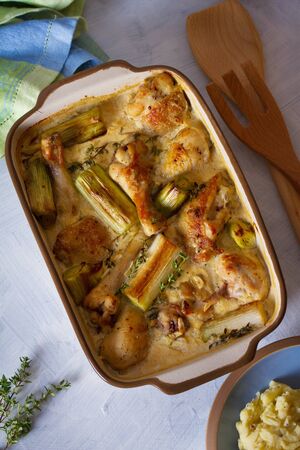 Chicken thighs and legs in sour cream sauce with leek and thyme. Overhead vertical imageの写真素材