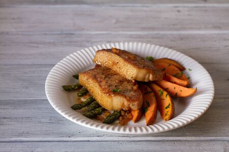 Honey garlic pork chops with asparagus and sweet potatoesの写真素材