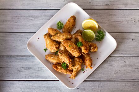 Crispy chicken wings with lemon and sauce. View from above, top view