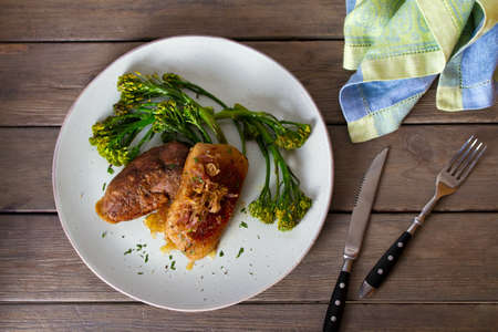 Duck breast fillets with caramelized onion and broccoli. View from above, top studio shot