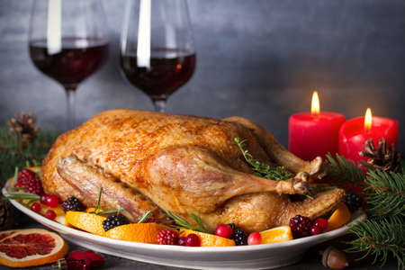 Whole roasted duck with oranges, berries and herbs. Christmas dinner meal table. Horizontal photoの写真素材