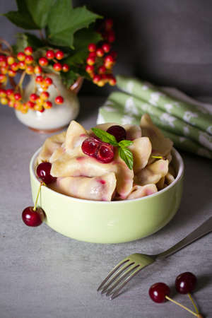 Dumplings, filled with cherries. Varenyky, vareniki, pierogi, pyrohy - popular dish in many countries. vertical photoの写真素材