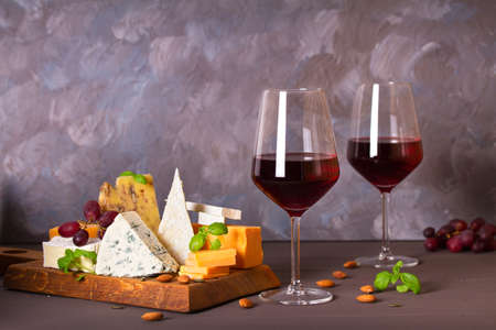 Glasses and bottle of red wine with cheese and nuts. Copy spaceの写真素材