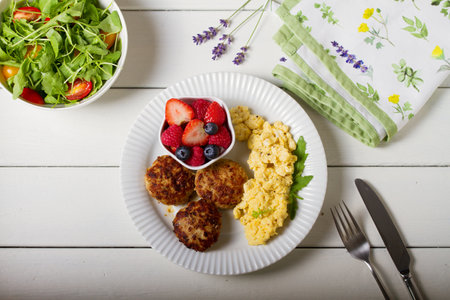Turkey burgers with scrambled eggs and berries. View from aboveの写真素材
