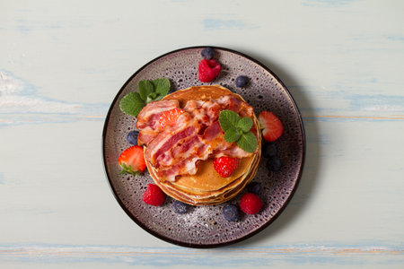 Fluffy pancakes with bacon and berries. High angle viewの写真素材