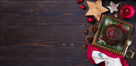 Fruit cake pudding and Christmas decorations. Fruitcake ball, traditional dessert on Christmas. Top view with copy spaceの写真素材