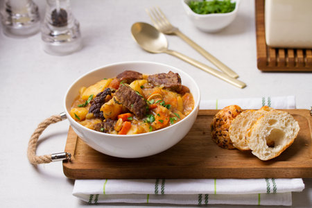 Delicious beef stew with vegetables in a white bowl on white background. High angle viewの写真素材