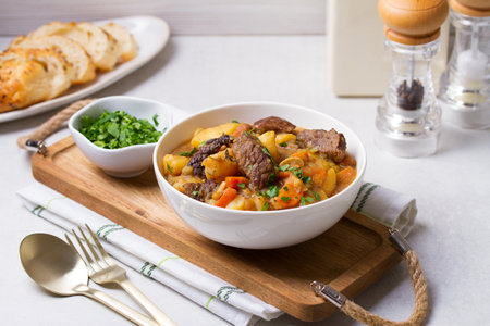 Delicious beef stew with vegetables in a white bowl on white background. High angle viewの写真素材