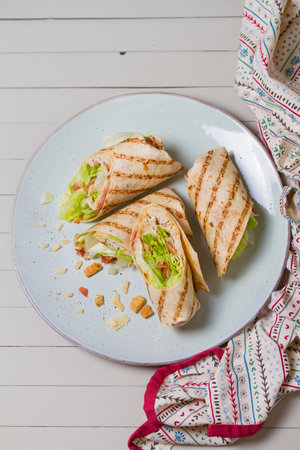 Turkey wraps on a plate. Tortilla, burritos, sandwiches, twisted rolls. High angle viewの写真素材