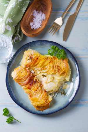 Potato and onion gratin on blue plate. Scalloped potatoes or potato bake. View from above, top viewの写真素材