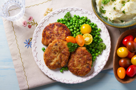Fish cakes with green peas. Fish patties or burgers. View from above, top studio shotの写真素材