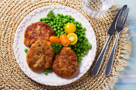 Fish cakes with green peas. Fish patties or burgers. View from above, top studio shotの写真素材