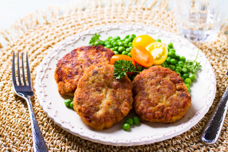 Fish burgers with vegetables on white plate. Fish patties or cakes