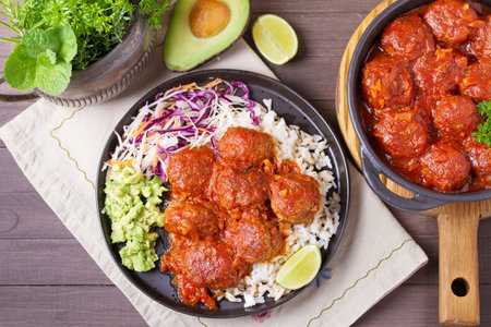 Colorful and appetizing plate of homemade meatballs served with with rice, avocado and creamy coleslaw. High angle viewの写真素材