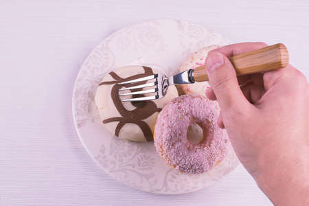 Hand With a fork prick chocolate donutの写真素材