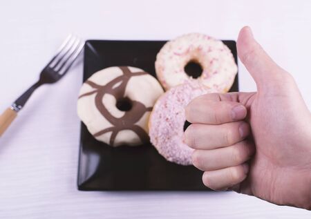 OK gesture of a hand in front of donutsの写真素材