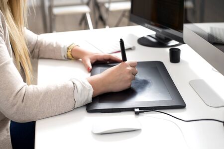 Woman hands using a graphics tablet in the officeの写真素材