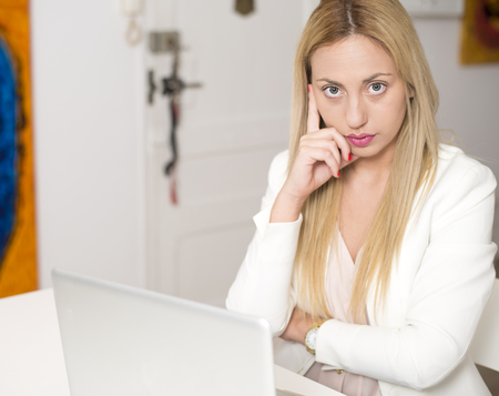 Attractive woman thinking in front of computer. Business.の写真素材