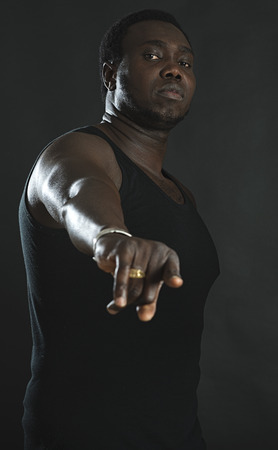 Studio portrait of african man pointing finger at camera.の写真素材