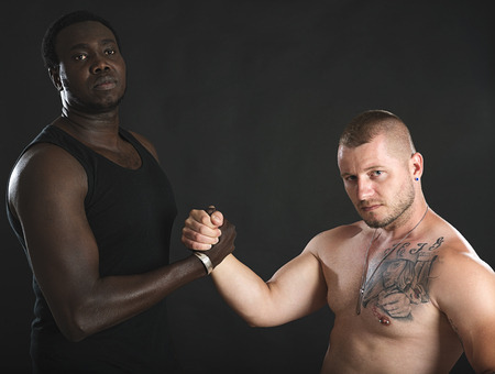 Two athletes Caucasian and African man shaking hands each other.の写真素材