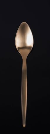 Spoon design and golden color on black backgroundの写真素材