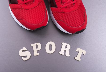 Red sneakers standing near sport letters. Horizontal studio shotの写真素材