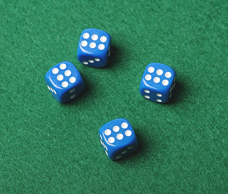Four blue dice with number six on green background. Horizontal shoot.の写真素材