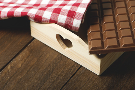 Chocolate tablet on a tray next to a napkin. Horizontal shoot.
