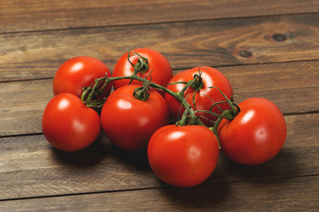 Tomatoes on brown wooden table. Horizontal shoot.の写真素材