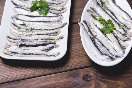 Tasty anchovies on white plates. Horizontal shoot.の写真素材