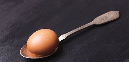 Brown egg on a metal spoon.の写真素材