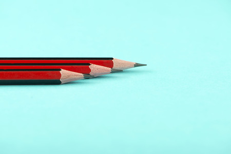 Close-up of three wooden pencils on blue background. Isolated.