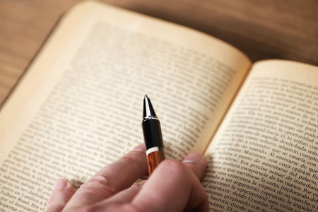 Hand with a pen on a book. Horizontal shoot.の写真素材