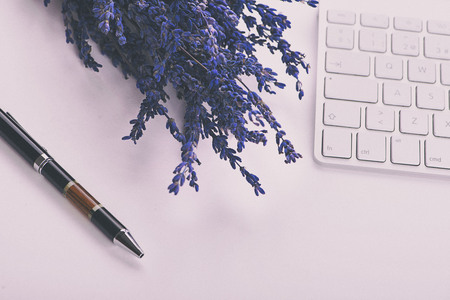 Lavender flower and ballpoint pen on computer keyboard on white background. Decor.の写真素材