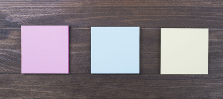 Multicolored paper notes on brown wooden background. Memo.の写真素材