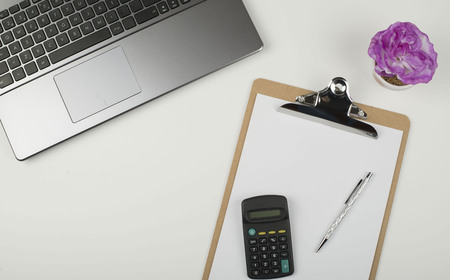 Folder with sheets, laptop and calculator on office table. Horizontal shoot.の写真素材