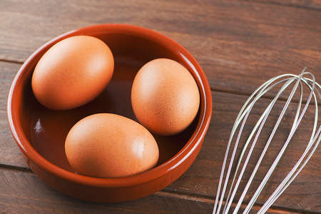 Eggs and cookware on wooden table. Horizontal shoot.の写真素材