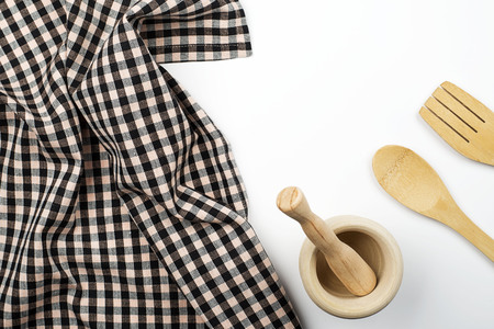 Background of kitchen tablecloth cutlery and wooden cookware on white background. Copy space....