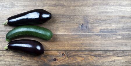Background of aubergines and a pickle on wooden background. Vegetables.の写真素材