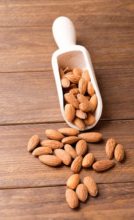 Almonds and wooden bowl. Vertical shoot.の写真素材