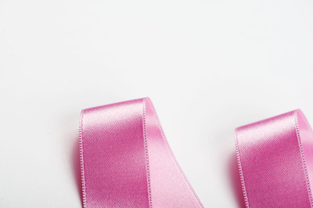 Pink ribbon with abstract shapes on white background. Isolated. Copy space.の写真素材