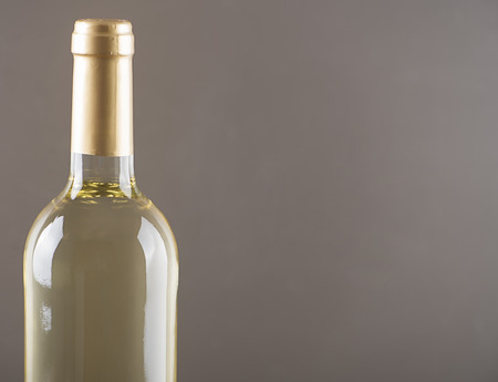 White wine bottle on gray background Horizontal studio shot. Copy space.の写真素材
